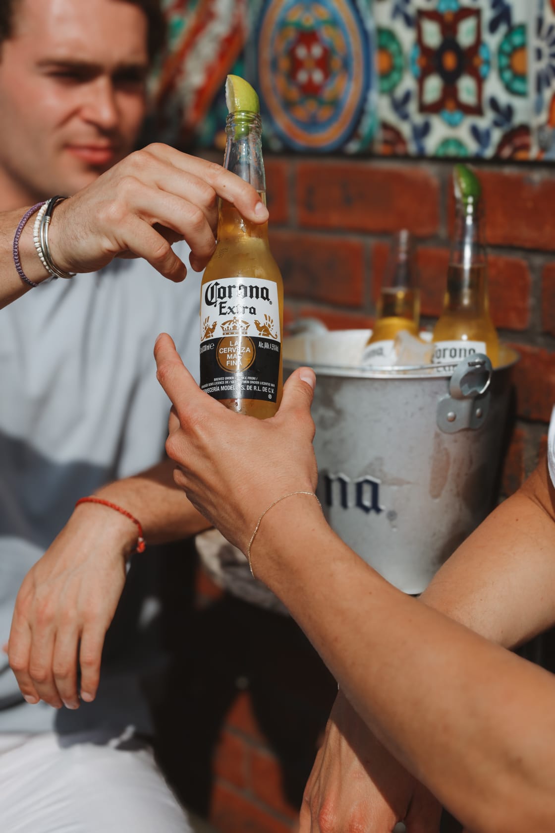 Twee gasten proosten met een flesje bier bij Het Plantsoen