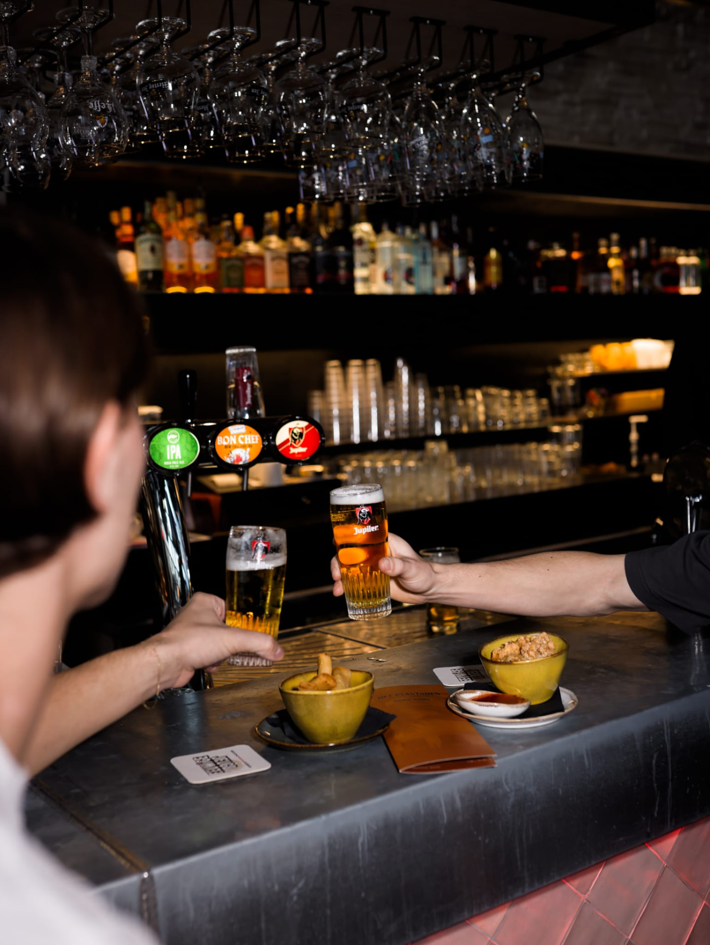 Proosten met twee glazen bier aan de bar van Het Plantsoen