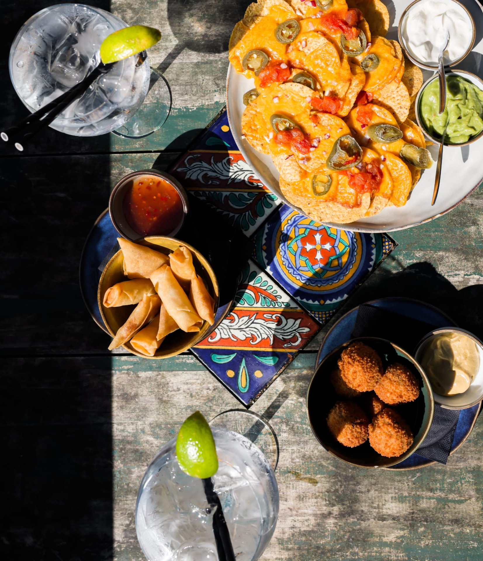 Borrelhapjes en gin-tonics aan tafel op het terras van Het Plantsoen aan het water